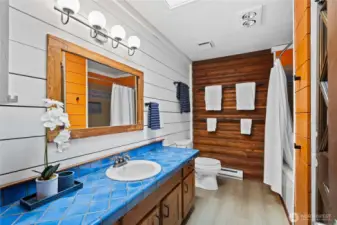Full bathroom with ample counter space and large mirror.