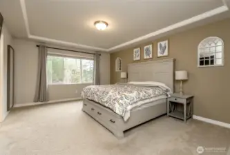 Spacious primary bedroom with large window