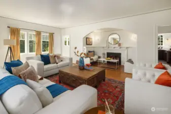 Large light filled living room with fireplace nook and hardwoods.