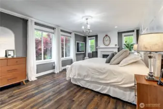 Notice the many windows and natural light in primary bedroom.
