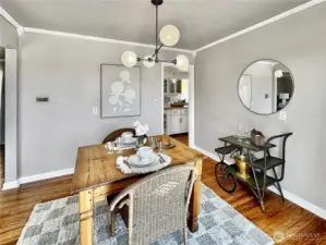 The dining room with crown molding offers easy access to both the kitchen and living room.