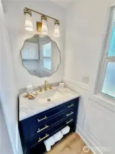 The hall bath also has a new vanity, new light fixture, lovely wainscotting and new flooring.