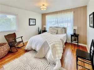 Second bedroom on the main floor also with oak floors and wood accent wall.
