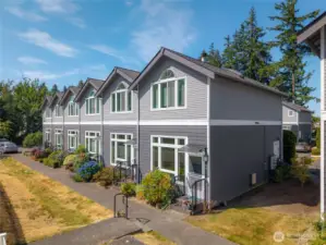 Architecturally interesting townhouses with front lawns and decks in back.