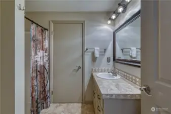 Primary ensuite with tile floors and tile counter tops.  Walk in closet is behind the door.