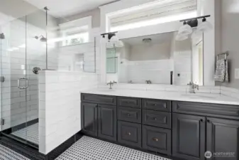 Recently remodeled primary bath with new quartz counters and tile shower.