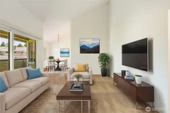 View of living room into dining area showing vaulted ceiling and slider out to deck. Virtually staged