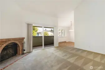 Living room with wood burning fire place, slider to deck and dining area