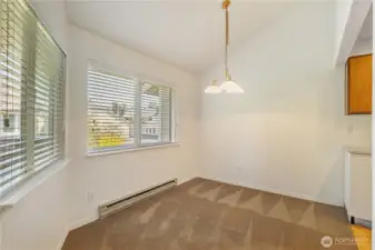 dining room with 2 large windows leading into kitchen