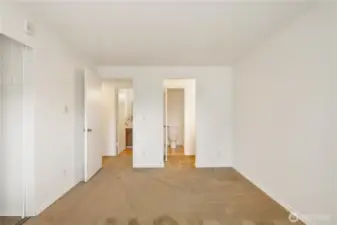 Primary look back towards vanity area and entrance to bath from primary