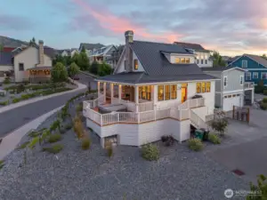 Exterior twilight view of home with wraparound porch.