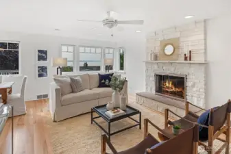 The living room offers a warm and inviting setting, anchored by a gas fireplace and accented with freshly painted walls and  refinished solid oak hardwood floors. Neutral tones and an open layout create a seamless flow into the dining area.