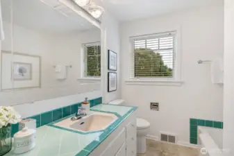 The main floor bath features both a tub and separate shower, with a layout spacious enough to accommodate a dual vanity. Classic tile accents and natural light give the space a fresh, functional feel.