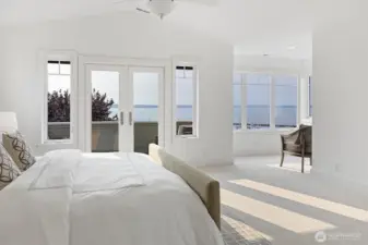 The primary suite is the retreat we all dream about—vaulted ceilings, walls of windows, and French doors opening to a private balcony with water views. A sunlit sitting area adds space to relax, making this room a true sanctuary.