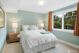 Bright and comfortable, this lower-level bedroom features a large window with garden views and ample natural light—an inviting retreat for overnight visitors or extended stays.