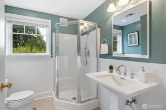A bright and functional ¾ bath with walk-in shower and pedestal sink serves the lower level, creating a convenient private suite feel when paired with the adjacent guest bedroom.
