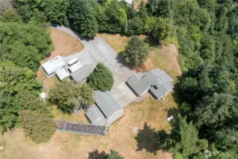 An Aerial view of the custom 3 bedroom home, and all outbuilding structures, and fully fenced Garden space.