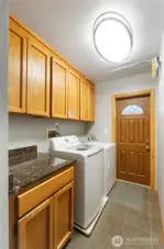 Laundry room with storage cabinets as you enter home from back door entry way.