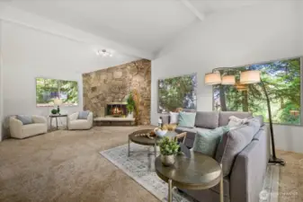 Light and bright living room with vaulted ceilings and wood fireplace.