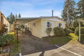 Large carport with parking space in front.