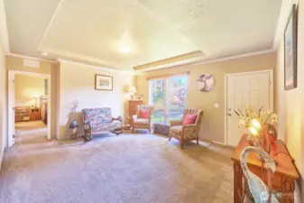 Front door opens to living room with charming tray ceiling