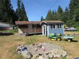 Small workshop, Bunk house, fire pit area and yes, John Deer mower w/ utility trailer stays with new owner. far Background is neighbors' area to the North.