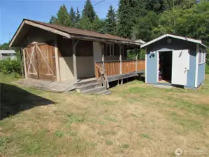 Large out building with covered walkway and double door storage area to left. Inside workshop is next photo.