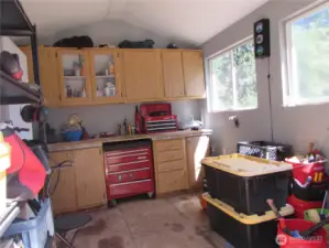 Insulated shop w/ power provides space to work on small projects w/ room to store them too. Shelf to left goes with Seller.