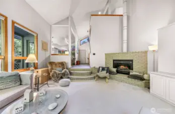 The sunken living room invites you in with soft carpet, tranquil colors, and cozy seating surrounded by nature.