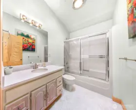 The upstairs hall bath is bright and clean with a vaulted ceiling and full tub-shower combo