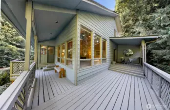 A wall of oversized windows connects the indoors to nature, while the deck creates a seamless flow for entertaining or relaxing outside.