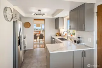 The remodeled kitchen features newer cabinets & slab countertops.