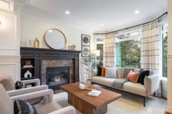 Large bay windows and gas fireplace anchor the living room.
