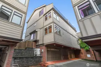 Two car garage from driveway. Notice the A/C condenser!