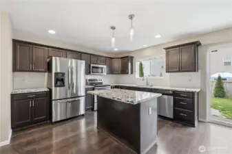 Kitchen with granite island and ample prep space.