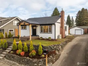 The covered front porch gives you respite from any rain while you unlock the door, and the black rod iron railing, along the concrete steps, adds charm to this already adorable vintage home.