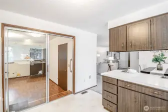 The family room off the kitchen has the clever design of a sliding glass door for a noise barrier