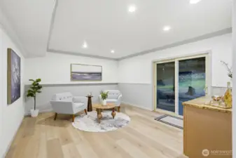 Lower-level Family Room with dry bar, including beverage refrigerator, artisanal timber cabinets and granite countertop, walk-out into the backyard.