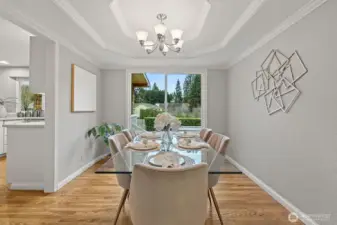Formal dining room featuring real hardwood floors, abundant natural light, and a designer coved ceiling.