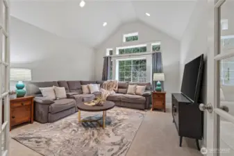 The HUGE bonus room boasts a vaulted ceiling, abundant lighting, and elegant glass French doors—ideal for a media room, home office, or flexible living space.