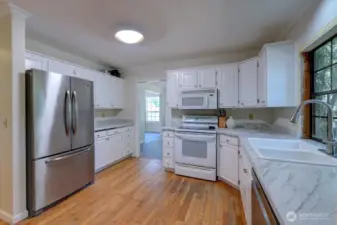 Kitchen has fresnly painted cabinets and new countertops. Original hardwood oak floors here.