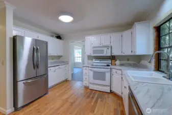 Kitchen has fresnly painted cabinets and new countertops. Original hardwood oak floors here.