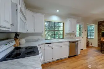 Window at sink overlooks back yard and out to lovely trees! Backyard also accessed from kitchen door. Really beautiful, peaceful view.