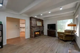 Family room is just to the side of the kitchen and to the right of the entry. Here you can see the home's second fireplace. Beamed ceiling adds yet more character to this lovely home.