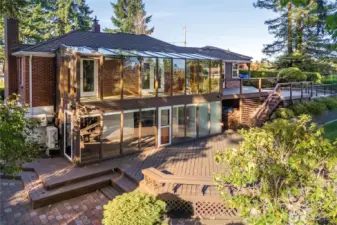 Back of the home showing the amazing sunroom that opens to the large multi-level entertaining deck with panoramic views of Mt. Rainier.