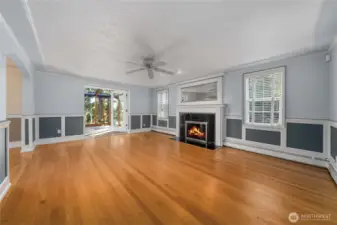 Gleaming hardwoods greet you in the main floor living room, along with a gas fireplace and wainscoting, that opens to the sunroom.