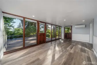 Another view of the flex space downstairs with a wall of windows to the beautifully private yard. There's a ductless mini-split on the main floor and also down here for A/C.