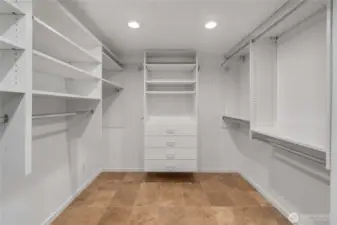 Walk-in primary closet with custom built-in space organizers.