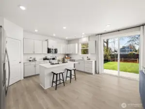 Open island kitchen with slab quartz counters, full height tile backsplash, soft-close cabinetry, and a walk in pantry.  Picture for representational purposes only, colors and features may vary.