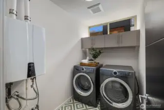 Laundry room next to primary